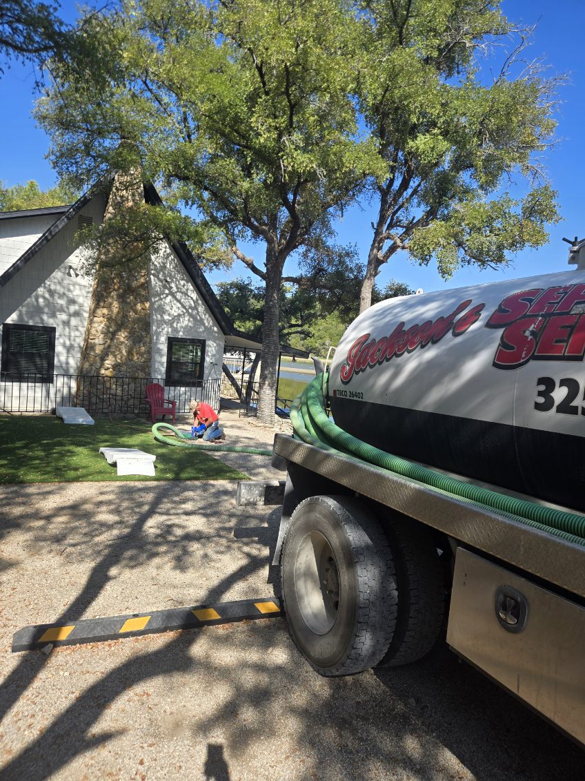 Technician at a septic lid next to the Jackson's service truck