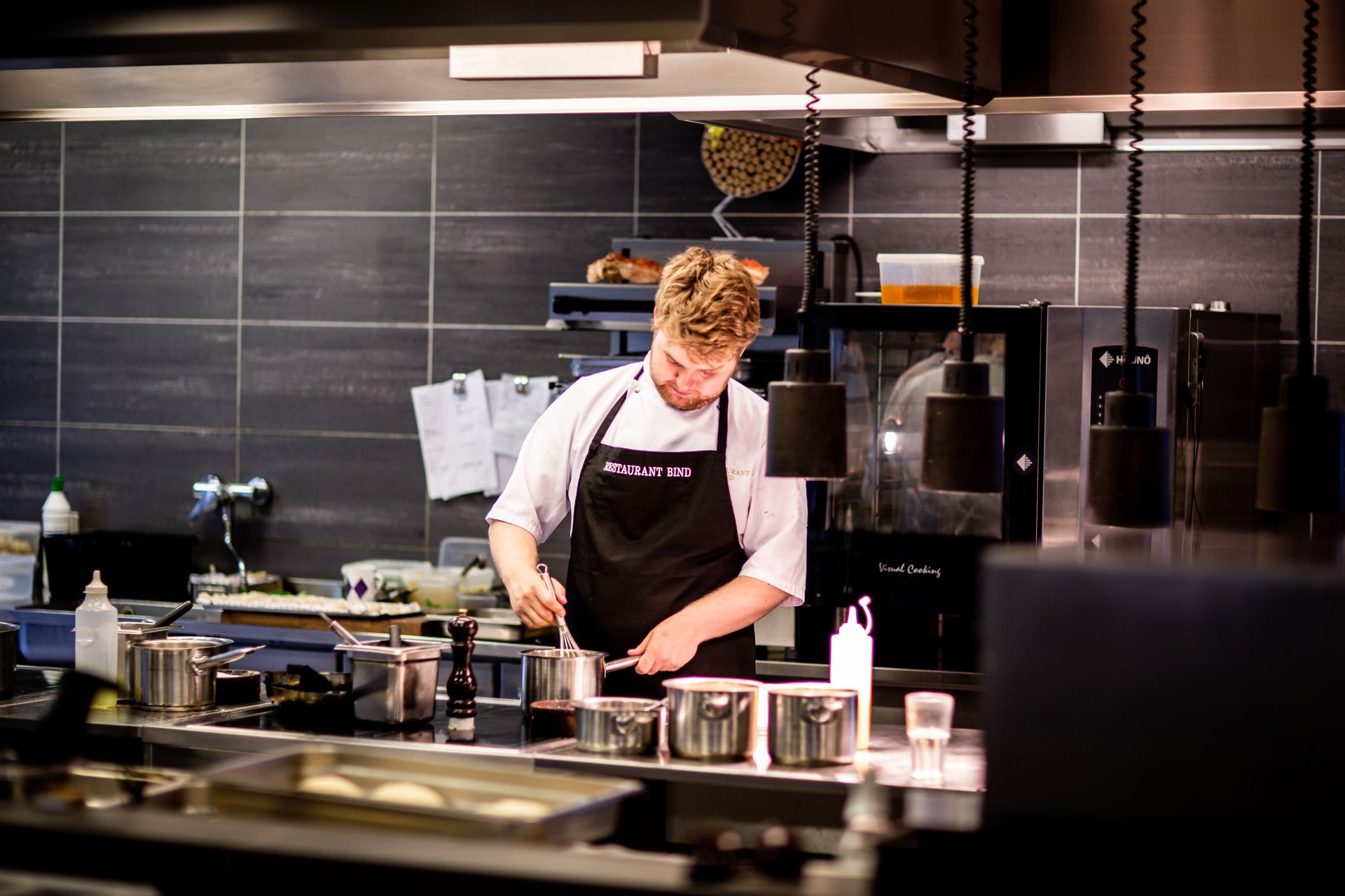 Chef working in a commercial restaurant kitchen that relies on grease trap service