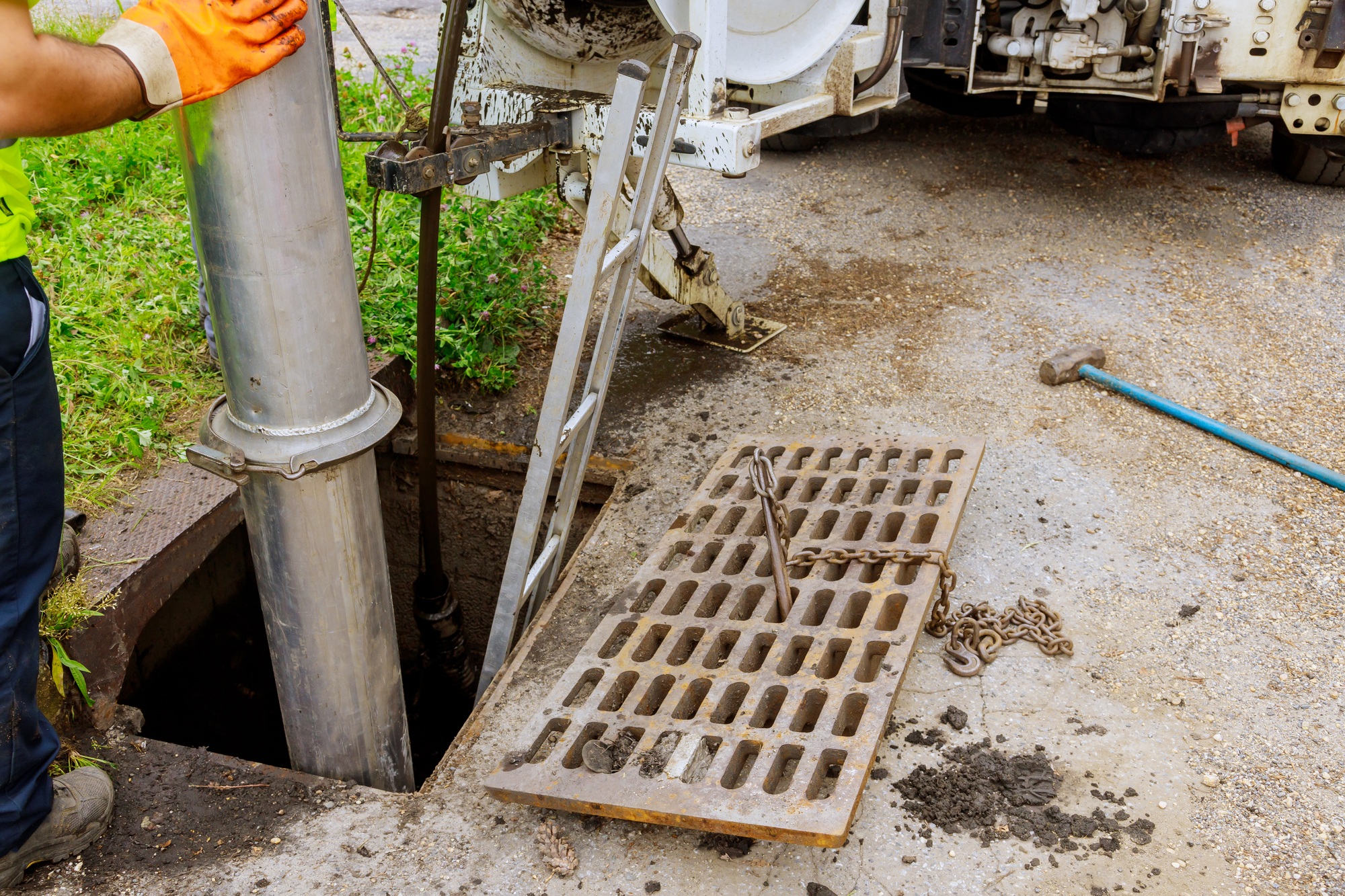 Technician pumping a septic tank through an open access lid
